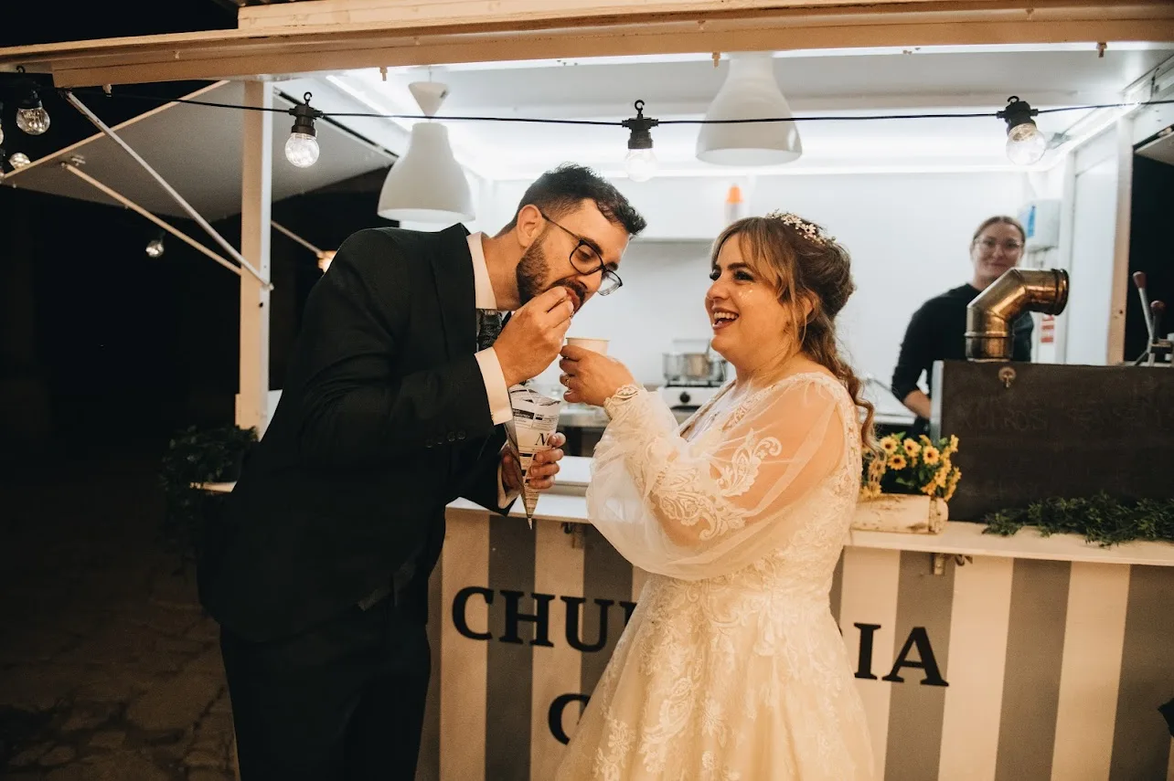Food truck de churros iluminado en boda nocturna
